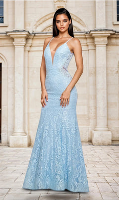 A woman poses outdoors in front of a stone building, wearing the La Femme Backless Long Lace Prom Dress 28355 in Cloud Blue, featuring a deep V-neckline and mermaid skirt.