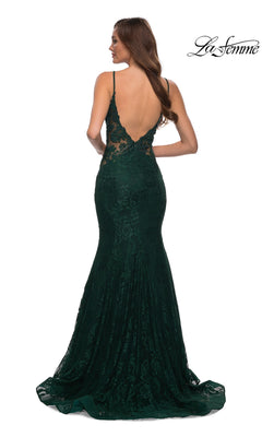 Woman modeling the La Femme Backless Long Lace Prom Dress 28355, featuring a dark green mermaid skirt, open back, delicate lace, and thin straps against a white background.