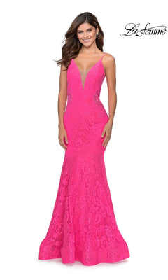 A woman in the La Femme Backless Long Lace Prom Dress 28355, a bright pink floor-length gown with a deep V neckline and thin straps, stands smiling. The "La Femme" logo is shown in the top right corner.