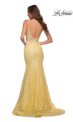 A woman models the La Femme Backless Long Lace Prom Dress 28355 in yellow, showcasing its low-cut back, thin straps, and mermaid skirt, photographed from behind against a plain white background.