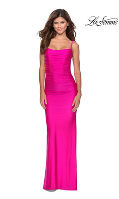 A woman models the La Femme Strappy-Back Long Tight Prom Dress 28398—bright pink, floor-length, sleeveless with thin straps and a ruched silhouette—against a white background. The La Femme logo is displayed in the top right corner.