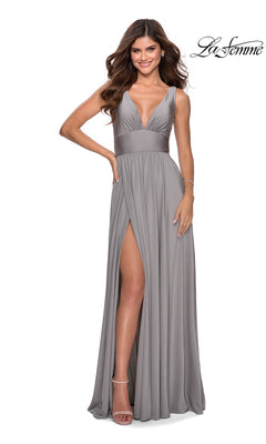A woman poses in the La Femme Deep V-Neck Long A-Line Prom Dress 28547, a sleeveless grey gown with a high slit and deep V-neckline, against a plain white background. The La Femme logo appears in the top right corner.