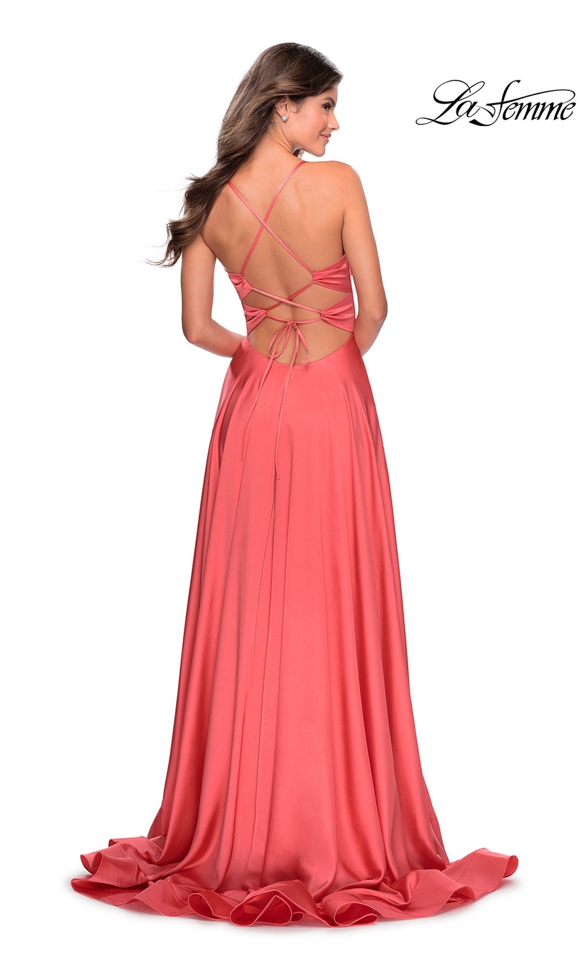 Woman wearing a La Femme Banded-Waist Long A-Line Prom Dress 28571 in coral pink satin, featuring a floor-length skirt and strappy open back, standing and facing away.