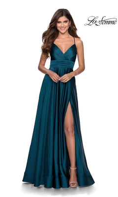 A woman smiles against a white background, wearing the La Femme Banded-Waist Long A-Line Prom Dress 28571 in teal satin with spaghetti straps and a thigh-high slit.