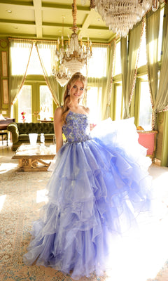 A young woman in a light purple Ava Presley 28575 one-shoulder prom ball gown stands in a sunlit, elegant room with chandeliers, green walls, and large windows.