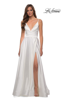 A woman wears the La Femme V-Neck Long A-Line Prom Dress 28607, a white satin gown with thin straps, deep V-neckline, and high front slit. She stands against a plain background with the La Femme logo at the top right corner.