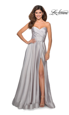 A woman in the La Femme Strapless Long A-Line Prom Dress 28608 in silver, featuring a sweetheart neckline and thigh-high slit, stands smiling with one hand on her hip. "La Femme 28608" logo appears in the top right corner.