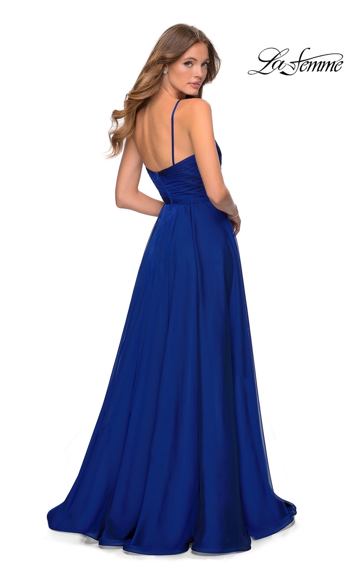A woman seen from the back wears the royal blue Long Prom Dress: La Femme 28611, a floor-length gown featuring thin straps and a pleated surplice bodice.