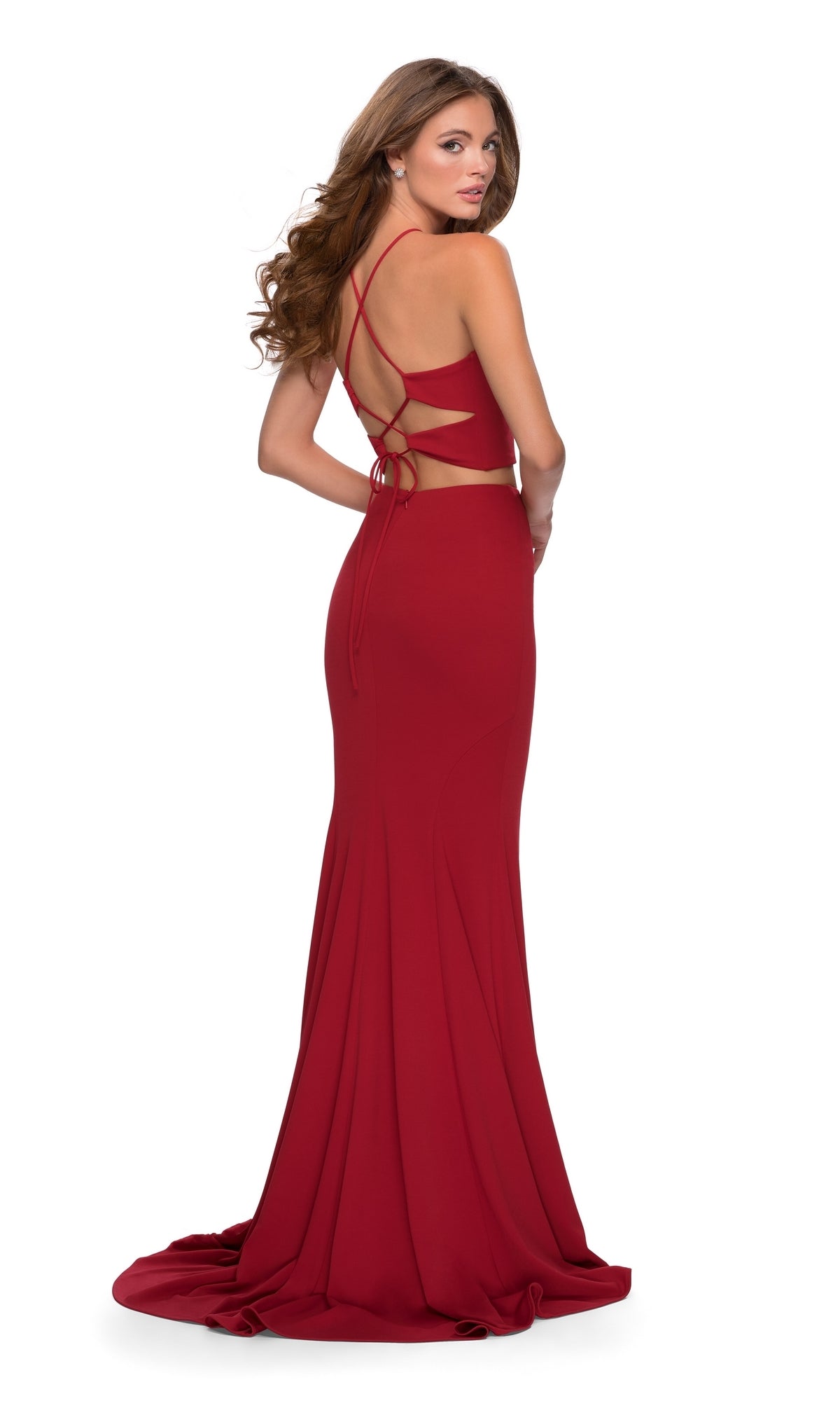 Woman wearing the Two-Piece Fitted Jersey Prom Dress: La Femme 28624, standing and looking over her shoulder against a white background.