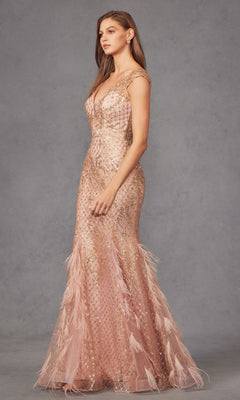 A woman stands in profile against a gray background, wearing the Juliet 286 Feathered Cap-Sleeve Long Prom Dress—a fitted blush pink mermaid gown with gold accents and feather details on the skirt.