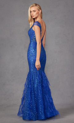 A woman wearing the Feathered Cap-Sleeve Long Prom Dress: Juliet 286, a floor-length, fitted blue glitter gown with a low back and feathered accents, stands against a gray background looking over her shoulder.