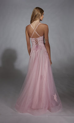 A woman faces away, wearing the Glitter Tulle Prom Ball Gown: Aerie Couture 286—a long pink corset-back dress with sheer overlay and floral accents—against a plain gray background.