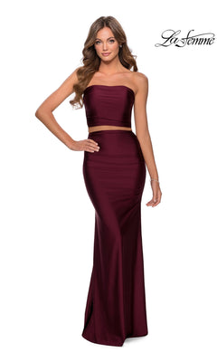 Woman wearing Long Prom Dress: La Femme 28703 in Dark Berry, strapless two-piece with fitted sheath skirt, smiling beneath the “La Femme” logo.