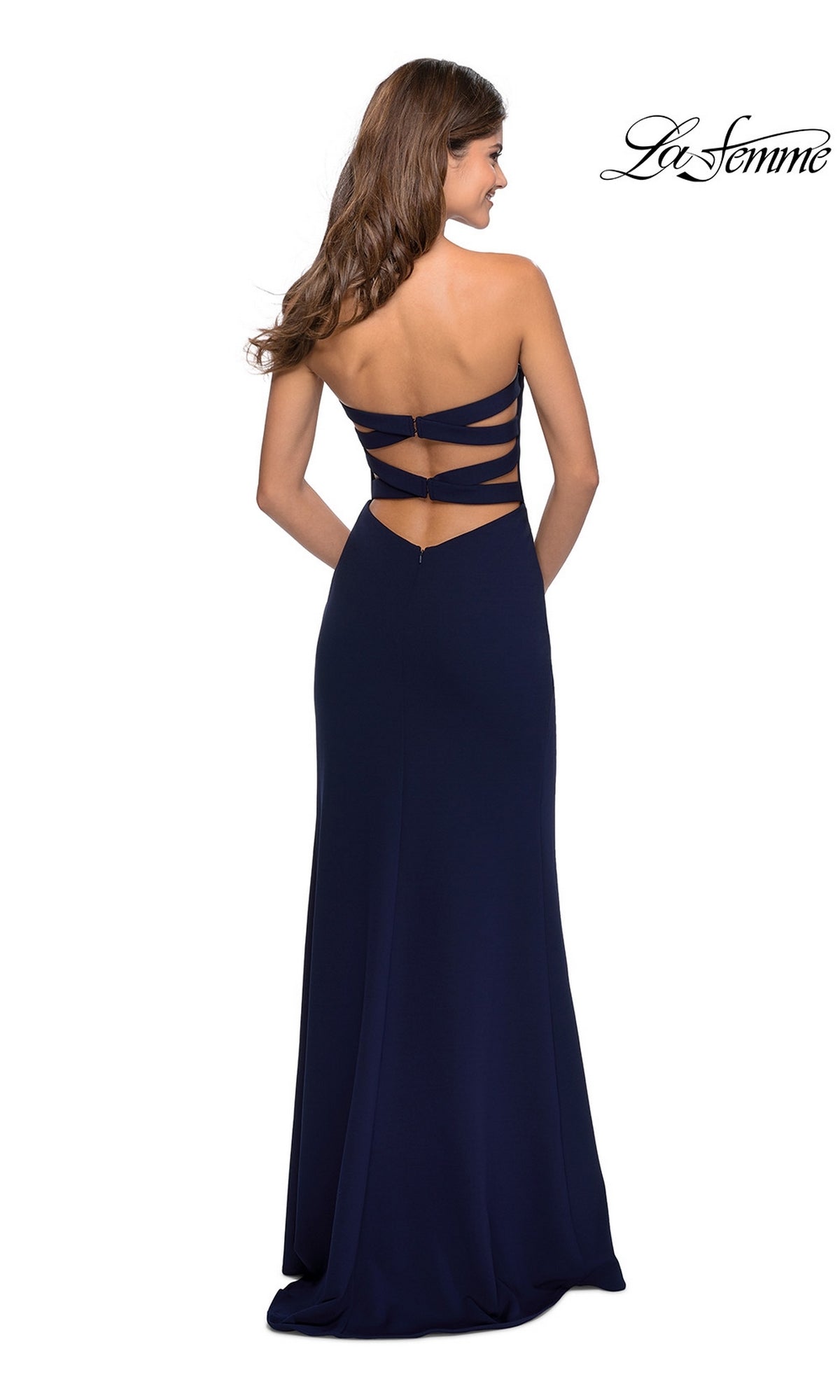 A woman in a La Femme Strappy-Back Long Strapless Prom Dress, navy blue and floor-length, featuring three horizontal back straps, stands facing away.