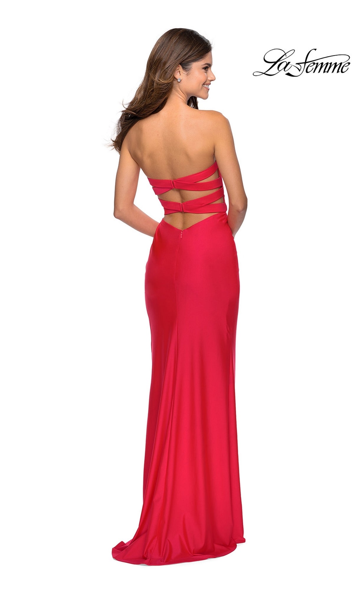 A woman in a bright red La Femme Sleek Strapless Long Prom Dress 28944 with an open strappy back, standing and facing away from the camera.