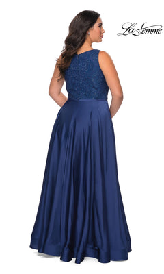 A woman seen from the back wearing a Long Plus-Size Prom Dress: La Femme 29004, a floor-length navy blue satin A-line gown with a rhinestone embellished bodice and a full, smooth skirt.
