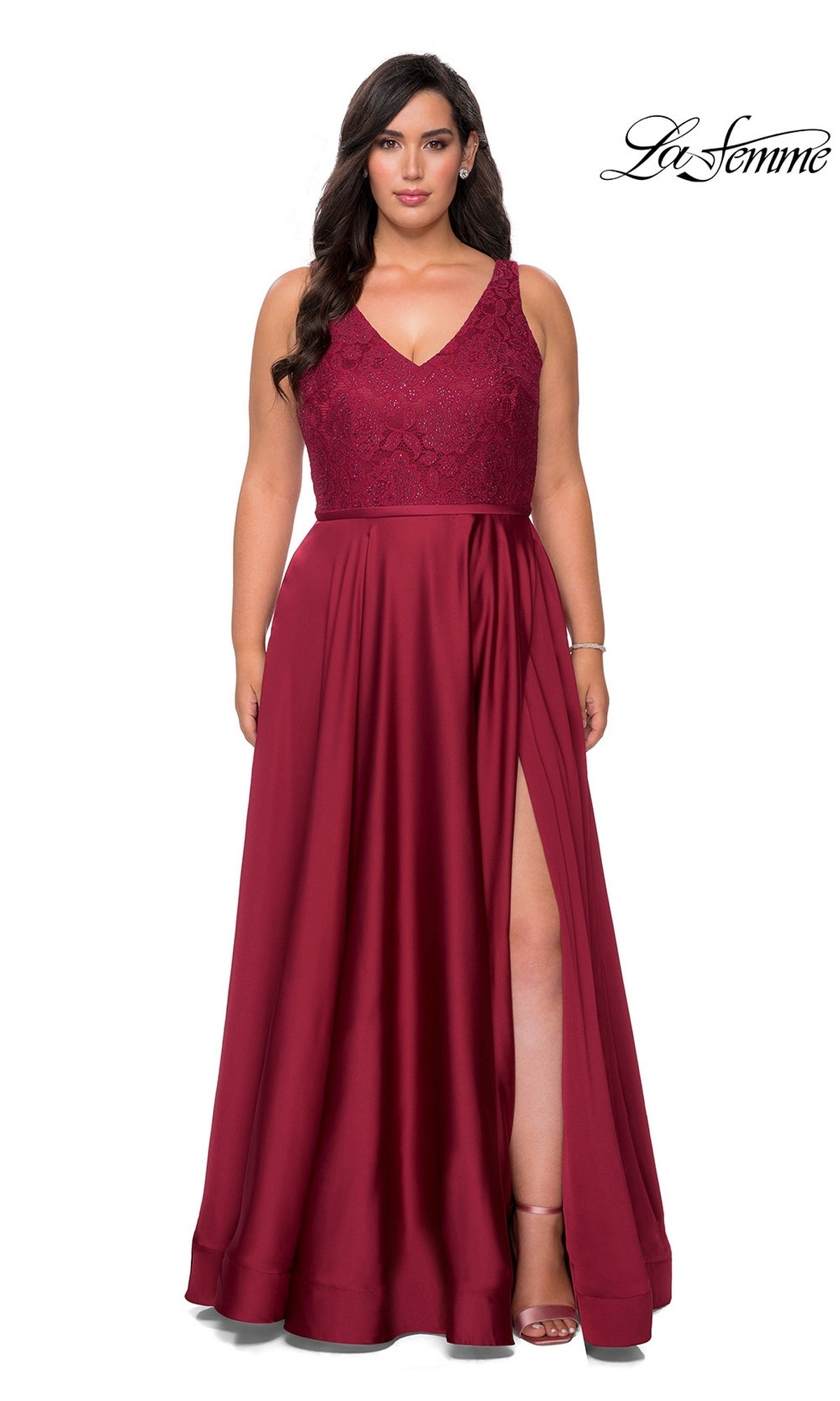 Plus-size woman wearing a wine-colored Long Plus-Size Prom Dress: La Femme 29004, featuring a floor-length satin A-line gown with a rhinestone-embellished lace bodice, V-neckline, and a high side slit.