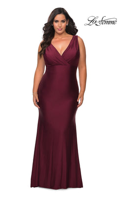 A woman wearing the Long Plus-Size Prom Dress: La Femme 29016 in dark berry, featuring a V-neckline, floor-length jersey skirt, and a faux wrap-style bodice.