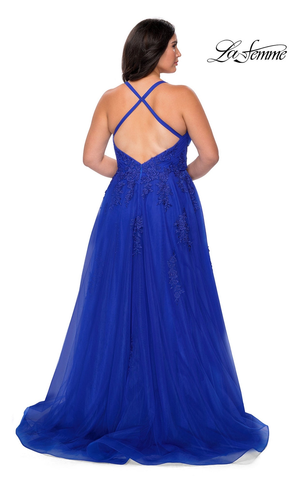 Wearing the La Femme Long Prom Dress 29021, a woman stands facing away, showcasing the royal blue gown’s lace details, crisscross straps, open back, and flowing skirt.