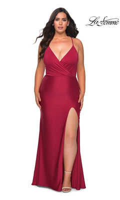 Plus-size model in a burgundy Long Plus-Size Prom Dress: La Femme 29022, a floor-length stretch jersey gown with a ruched V-neckline, spaghetti straps, and a thigh-high slit.