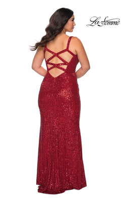 A woman wears the Long Plus-Size Prom Dress: La Femme 29037, a floor-length red sequin gown with an open-back design and strappy crisscross detailing.
