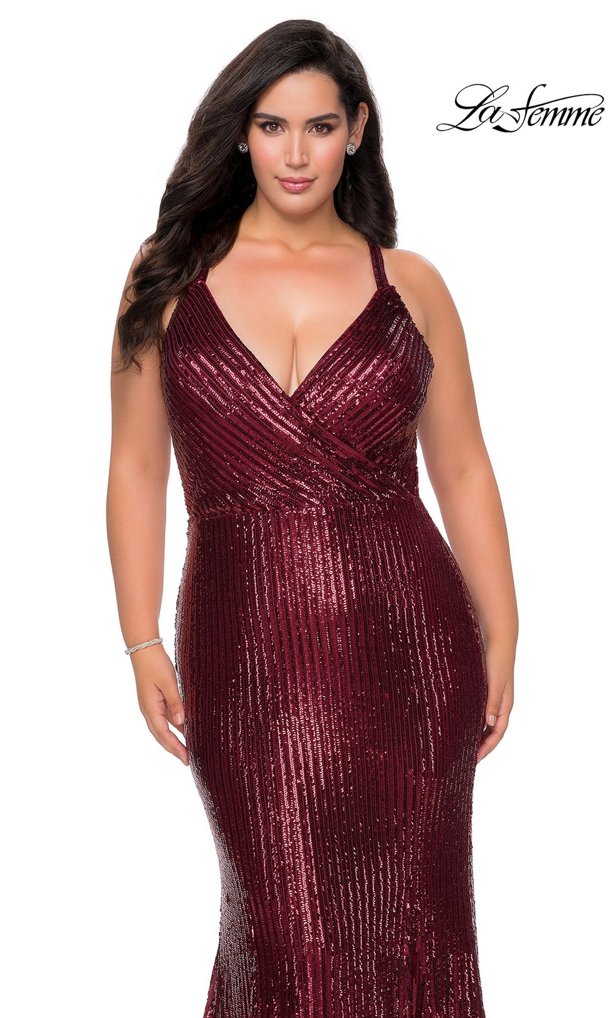 A person wearing the deep red, floor-length, sequin mermaid Long Plus-Size Prom Dress: La Femme 29051, featuring a V-neckline and a crisscross bodice.