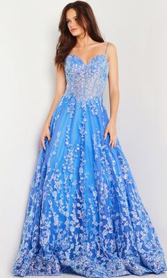 A woman stands against a light background wearing Jovani Long Prom Dress 29072—a floor-length turquoise blue gown with a sheer corset bodice, spaghetti straps, and floral sequin embroidery.