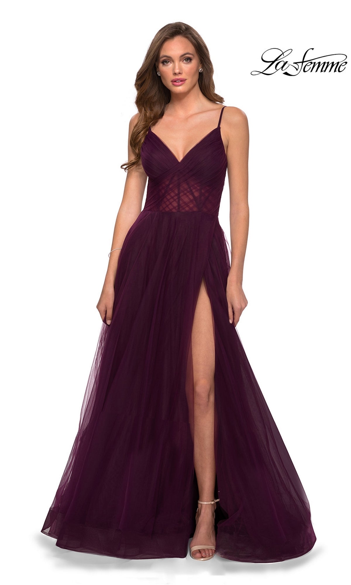 A woman wearing the La Femme Sheer-Waist Long A-Line Prom Dress 29076 in deep purple poses against a white background. The sleeveless dress has thin straps, a v-neckline, and a thigh-high slit for an elegant formal look.