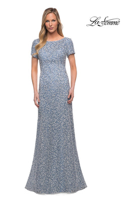 A woman models the Long Formal Dress: La Femme 29134, a modest, light blue floral sheath gown, standing against a plain white background with the “La Femme” logo top right.
