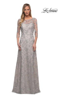 Woman in a Pearl Silver Long Formal Dress: La Femme 29153 with sheer three-quarter sleeves and floral lace, standing against a white background with “La Femme” logo.