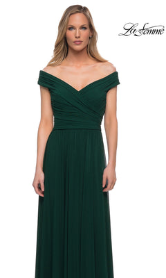 Woman in Long Formal Dress: La Femme 29168—off-the-shoulder, dark green, ruched bodice, A-line skirt—standing before a plain white background. “La Femme” logo top right.