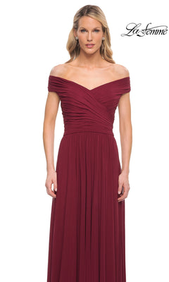 Woman wears Long Formal Dress: La Femme 29168—an off-the-shoulder, floor-length burgundy gown with ruched bodice and A-line skirt—against a white background.