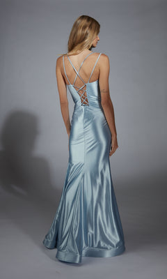 A woman wears the Aerie Couture 291 long prom dress, featuring light blue satin, a corset bodice, crisscross straps, an open lace-up back, and an elegant floor-length hem as she stands facing away.