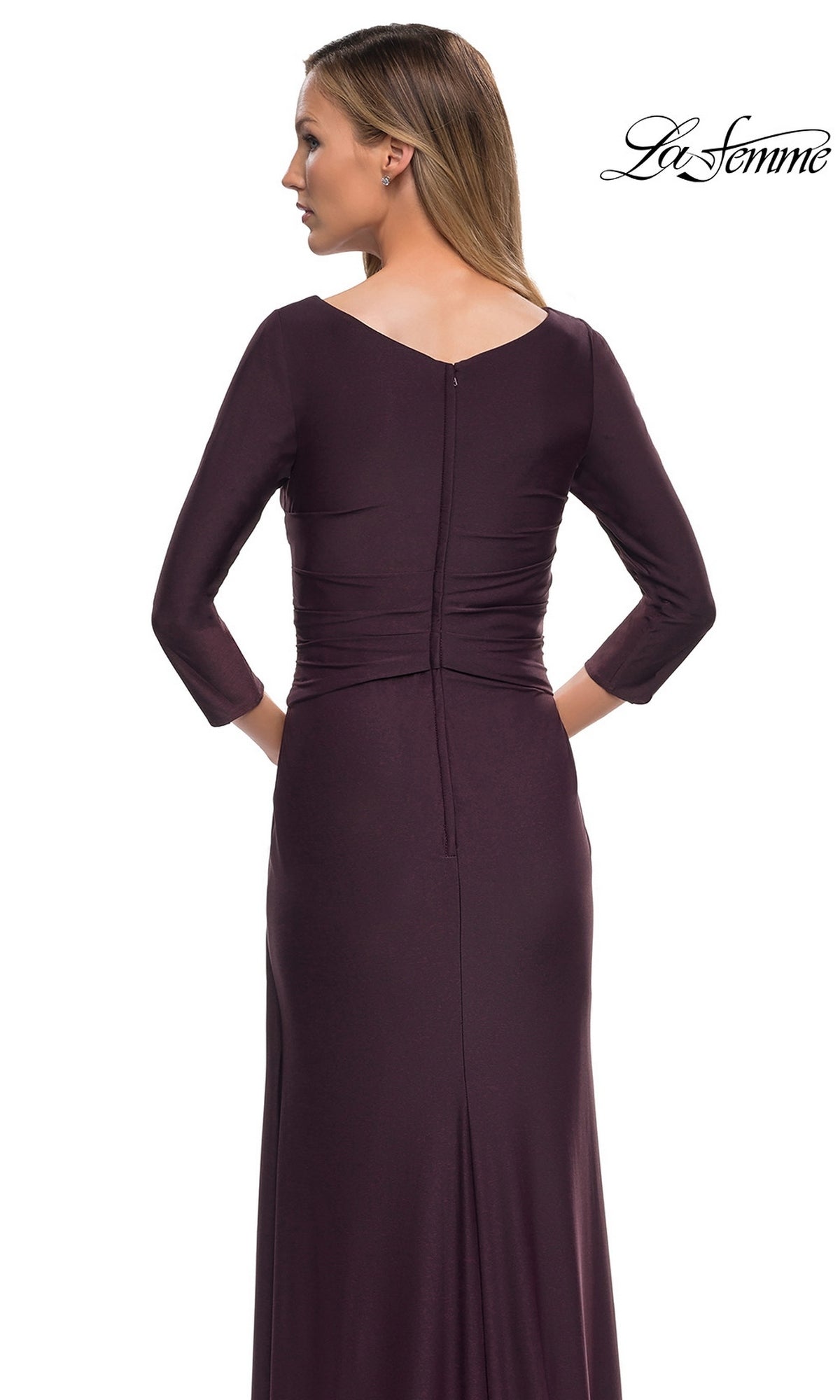 A woman is seen from the back wearing the Long Formal Dress: La Femme 29223, a fitted sheath gown with three-quarter sleeves and a V-neckline.