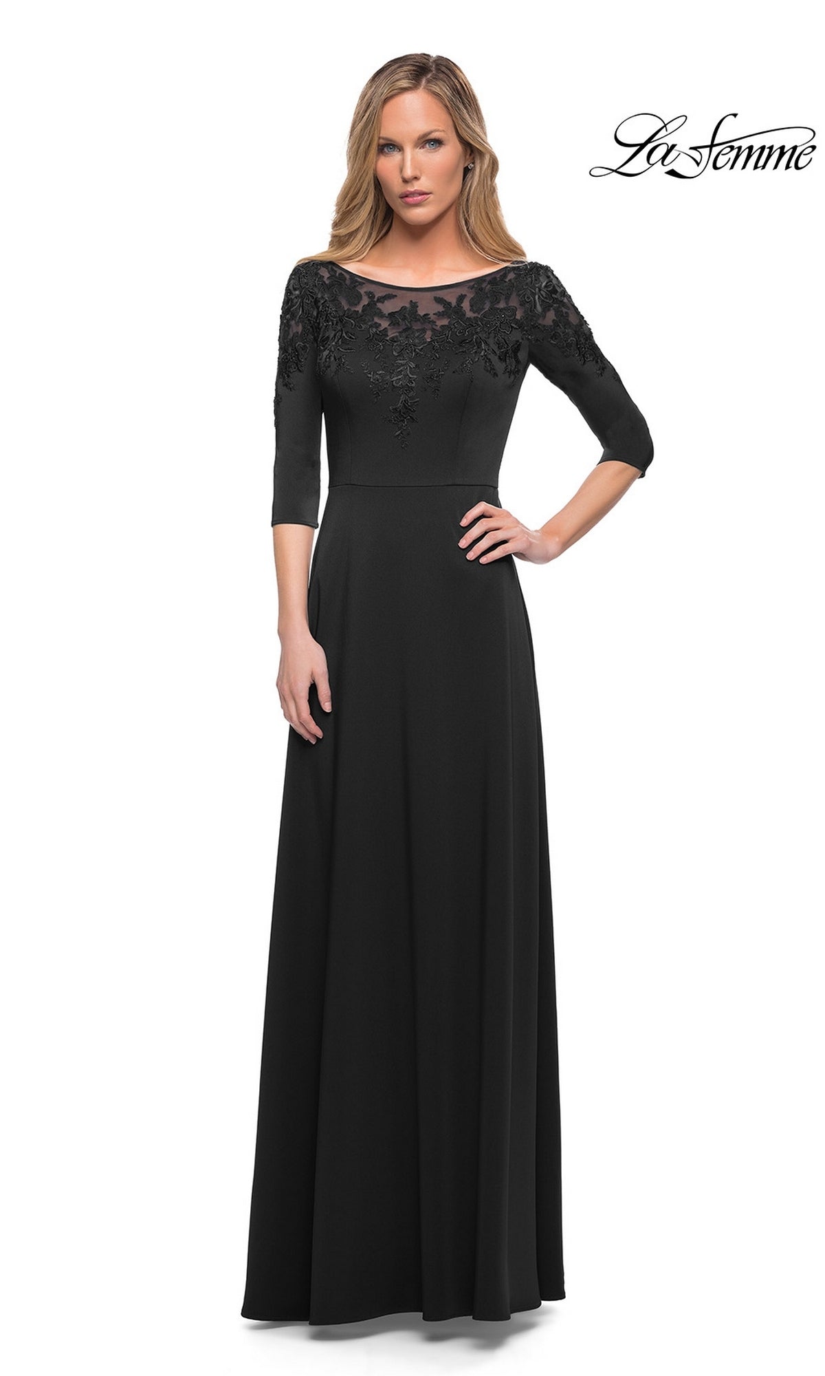 Woman in a black Long Formal Dress: La Femme 29227 with an A-line silhouette, lace bodice, and three-quarter sleeves, standing against a white background.