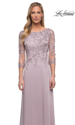 Woman in a light lavender Long Formal Dress: La Femme 29251 with sheer, floral-embroidered lace sleeves, standing against a white background. “La Femme” logo at top right.