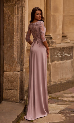 Woman in a mauve Long Formal Dress: La Femme 29251 stands on a stone path by an old building, facing away from the camera.