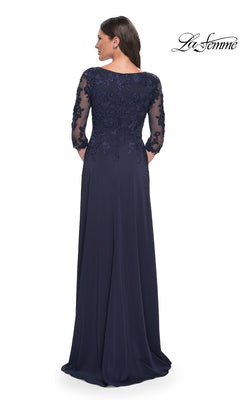 Woman in a dark blue Long Formal Dress: La Femme 29251 with lace details and three-quarter sleeves, back to camera. La Femme logo at top right.