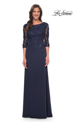 Woman in a navy Long Formal Dress: La Femme 29251 with sheer lace sleeves and floral details, smiling against a white background.