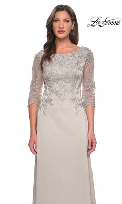 Woman in a light gray Long Formal Dress: La Femme 29251 with lace and sheer three-quarter sleeves, standing against a white background. The “La Femme” logo is at the top right.