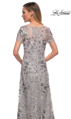 Back view of a woman wearing a modest long silver La Femme 29281 formal dress with short sleeves and floral embroidery.