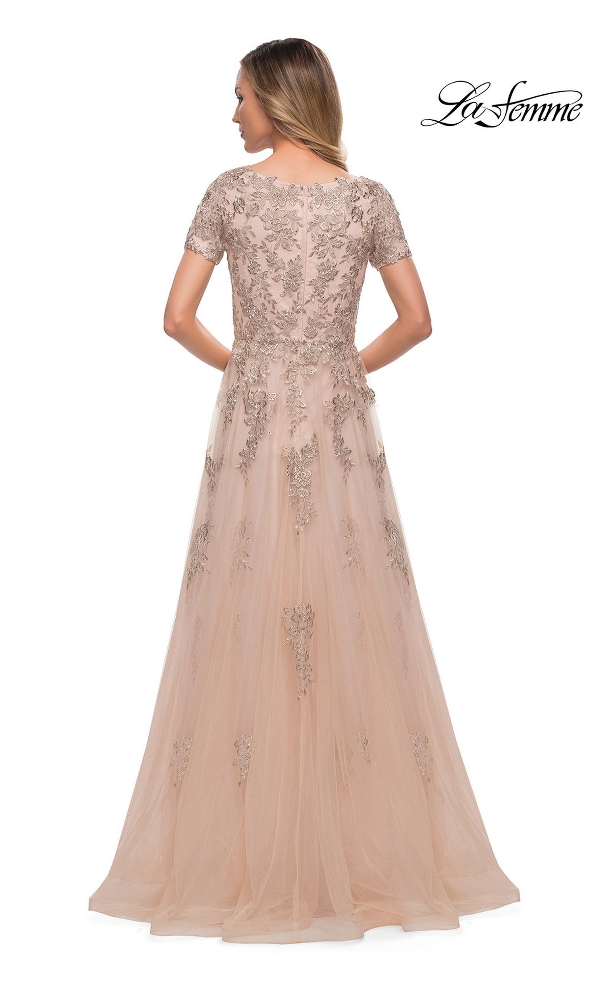Woman faces away in the floor-length, short-sleeve pink tulle Long Formal Dress: La Femme 29290 with floral embroidery and metallic lace appliques; “La Femme” logo top right.