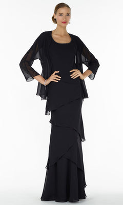 A woman in a black Alyce 29292 long formal dress with a sheer black shawl, standing against a plain white background.
