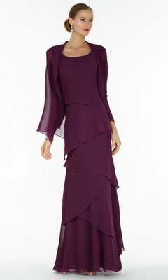 A woman in an eggplant Alyce 29292 long formal sleeveless dress with jacket and layered ruffles stands against a plain white background.