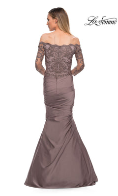 A woman faces away in a mauve off-the-shoulder Long Formal Dress: La Femme 29324 with lace sleeves and a fitted, ruched satin skirt. The “La Femme” logo is in the top right corner.