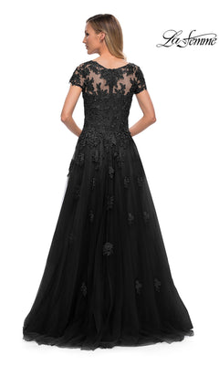 Woman wearing the Long Formal Dress: La Femme 29380, featuring tulle, floral lace appliques, and a sheer back panel, stands with her back to the camera.
