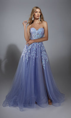 A woman stands against a plain gray backdrop wearing the Aerie Couture 293: a strapless glitter prom ball gown with floral lace embroidery and a flowing tulle skirt in lavender.