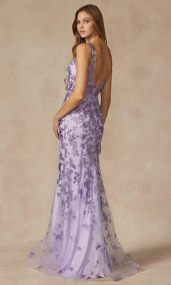 A woman models the Juliet 294 Glitter-Print Long Prom Dress, featuring a floor-length lavender design with floral lace embellishments and an open back, against a neutral background.