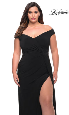 A woman wearing a La Femme 29474 off-the-shoulder black matte jersey evening gown with a high side slit.