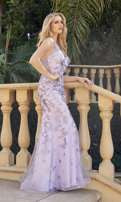 A woman wearing the Glitter-Print Long Prom Dress: Juliet 294 stands by a beige stone railing with greenery in the background.